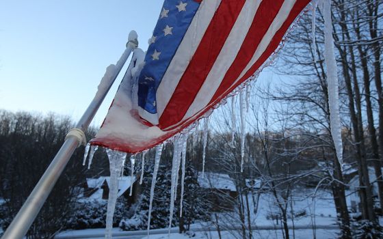 Icicles hang from a frozen U.S. flag on the front porch of a home in Waynesville, North Carolina, Dec. 26, 2020. (CNS/Bob Roller)